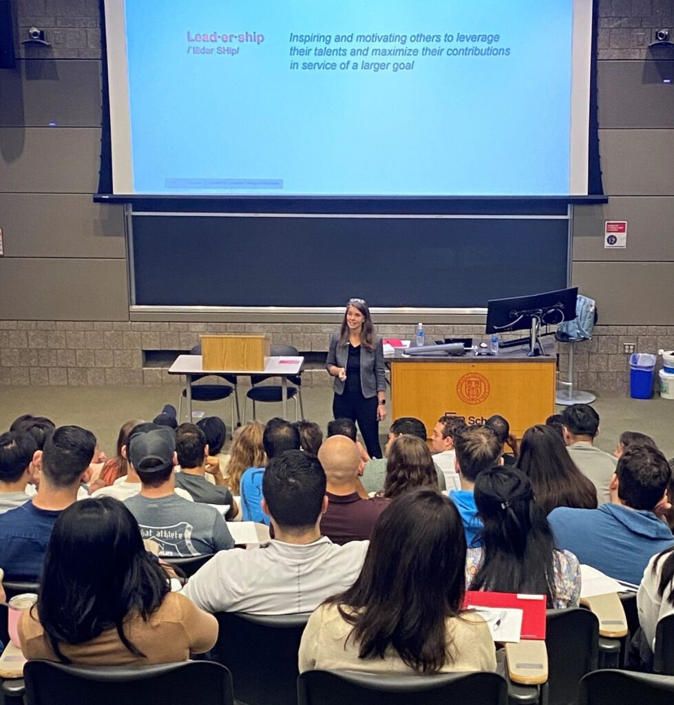 Laura Georgianna, Executive Director of Leadership Programs, at the front of a classroom presenting to MBA students.