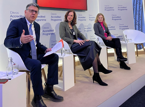 One man and two women site on stage for a panel discussion.