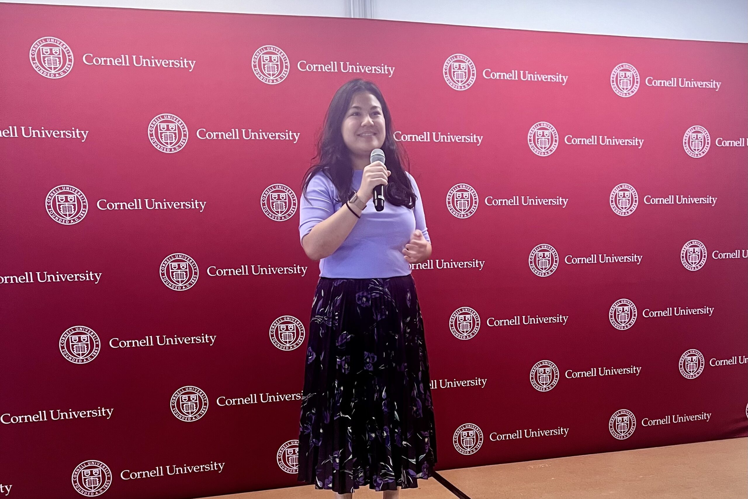 A picture of Ain Razali in front of a Cornell backdrop.