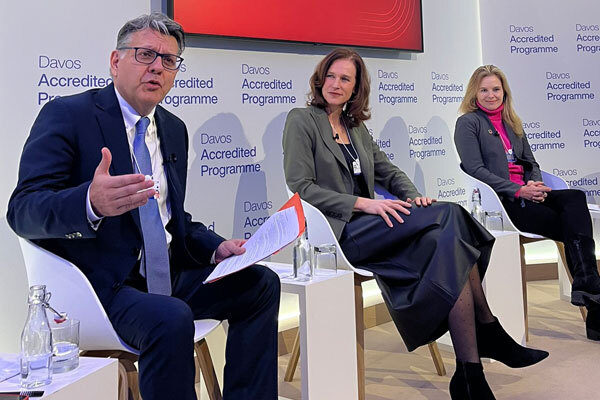 One man and two women site on stage for a panel discussion.